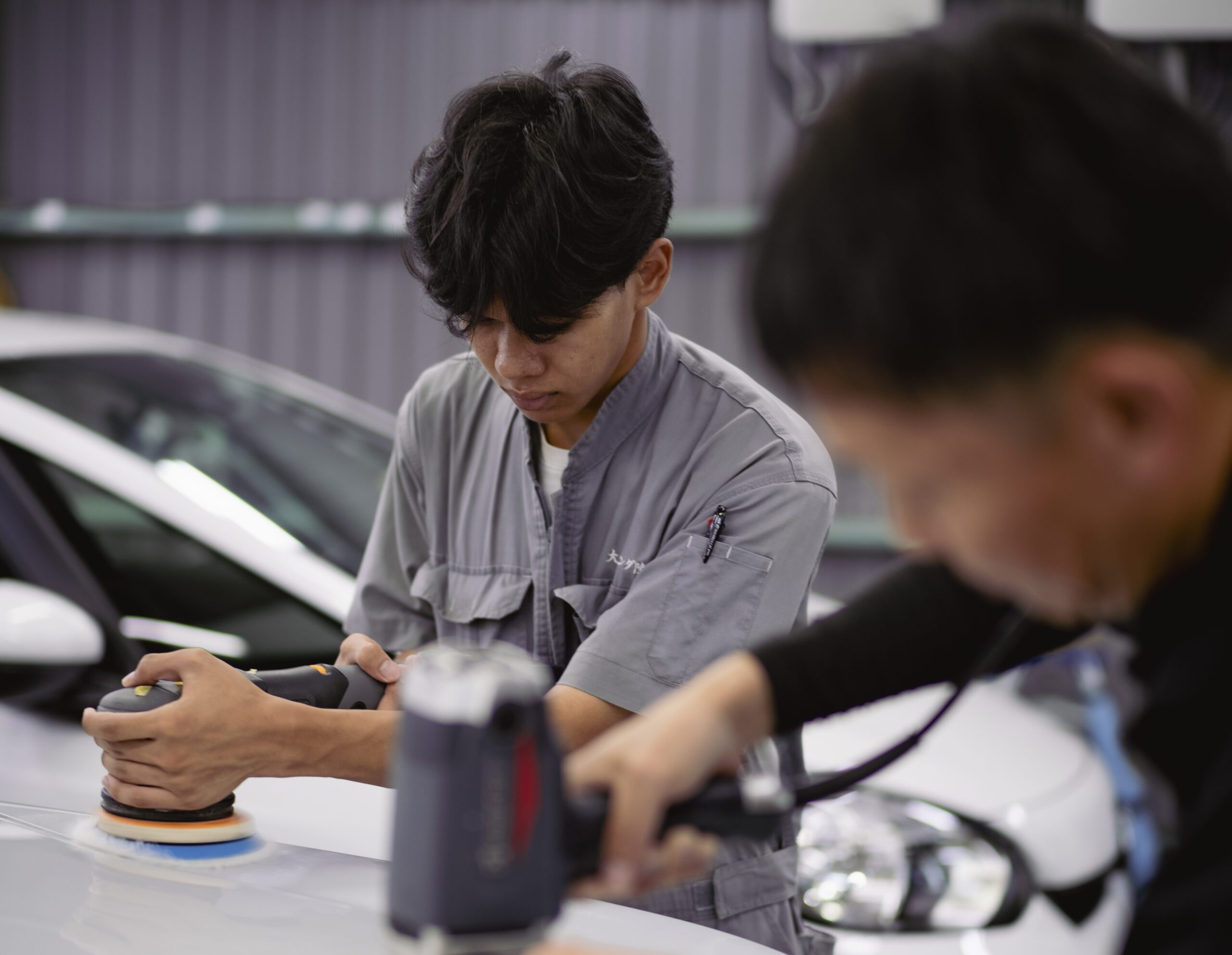 車のボディを丁寧に磨くスタッフ